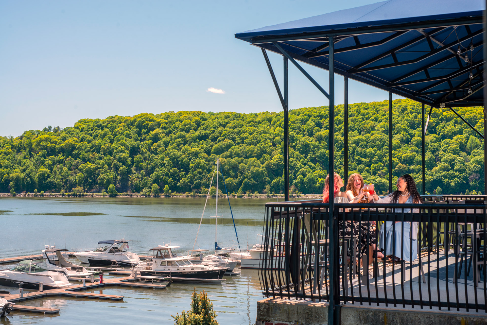 edited-Shadows-on-the-Hudson-Summer2026-lunch-with-models-18 Patio dining area overlooking the Hudson River and marina.